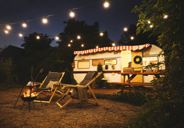 istock Water heating on open fire near trailer at night. Camping season 1365347453