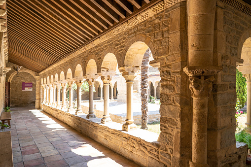 Roda de Isabena cathedral of San Vicente cloister arcade in Ribagorza of Huesca in Aragon Spain. this cloister of the cathedral is from century XII, having a trapezoidal plan and semicircular arches on which a roof rests that pours rainwater into a cistern
