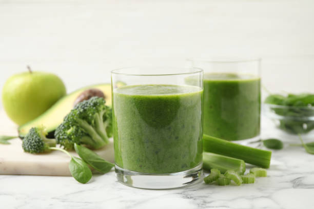 istock Delicious fresh green juice on white marble table 1365349587