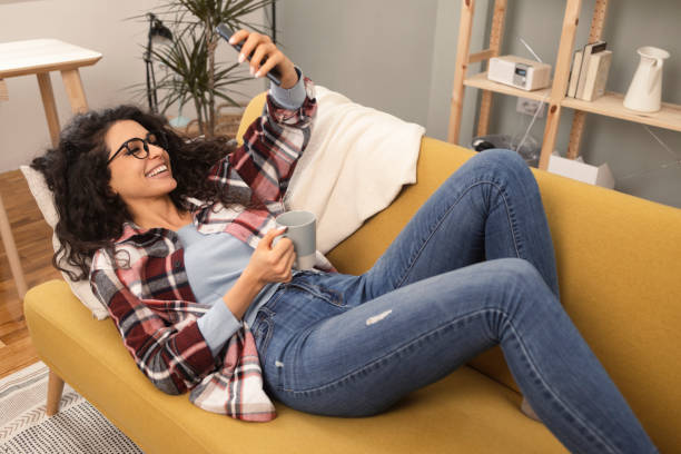 istock Woman relaxing on the sofa, enjoying coffee and making a video call 1365349897