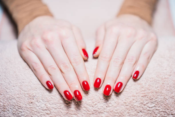 kobiece dłonie z pomalowanymi na czerwono paznokciami - red nail polish zdjęcia i obrazy z banku zdjęć