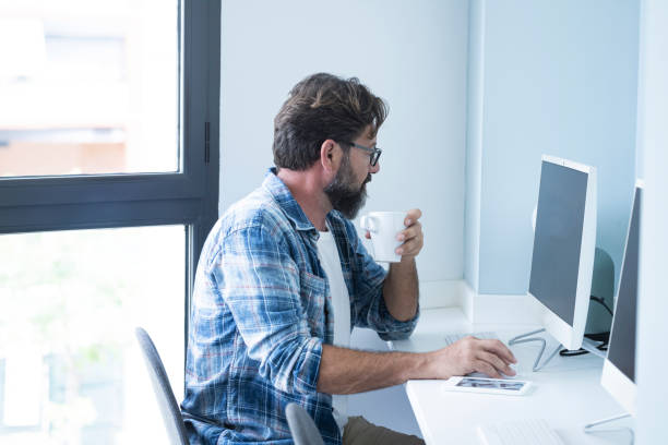 istock Side View Of Businessman Drinking Coffee While Working At Office 1365352612