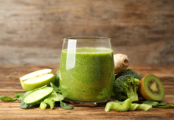 istock Green juice and fresh ingredients on wooden table 1365356697