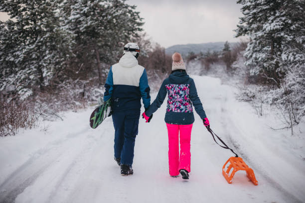 istock A young couple is having fun on a snowy mountain. View from behind 1365360339