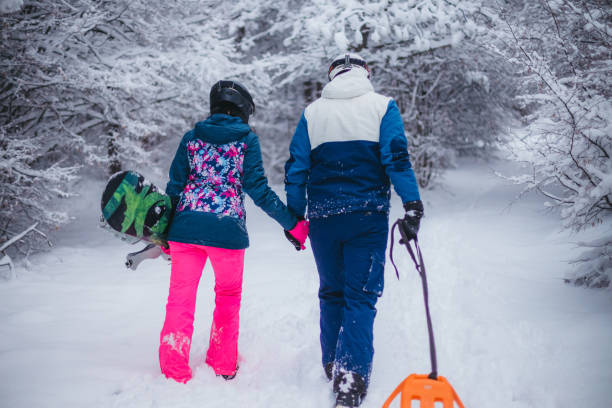istock A young couple is having fun on a snowy mountain. View from behind 1365360343