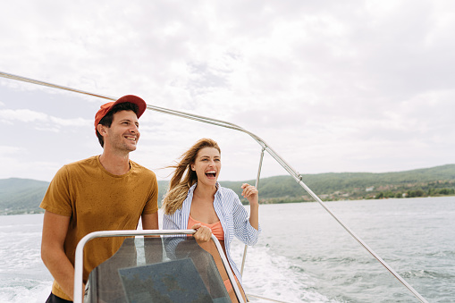 Photo of a smiling couple taking a boat ride on the sea