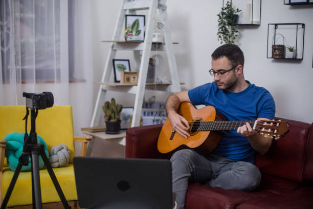 istock Man giving guitar lesson via streaming 1365362390