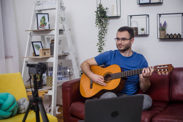 istock Man giving guitar lesson via streaming 1365362437