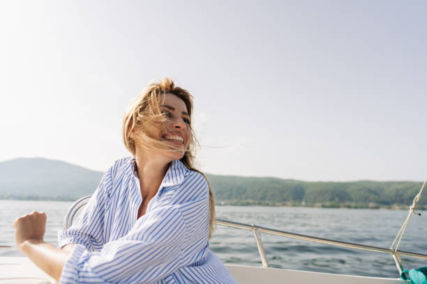 istock Smiling woman taking a boat ride on the sea 1365362496