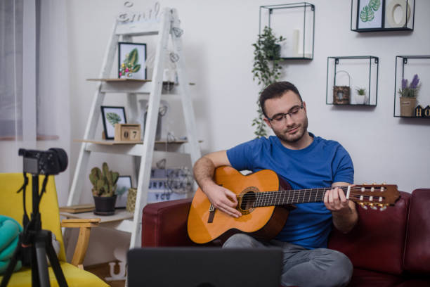 istock Man giving guitar lesson via streaming 1365362527