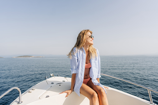 Photo of a smiling woman enjoying a summer day on the boat