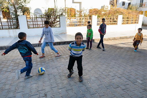 Sharm el-Sheikh-Egypt - 08.01.2022: Children play football on the road in a residential complex.