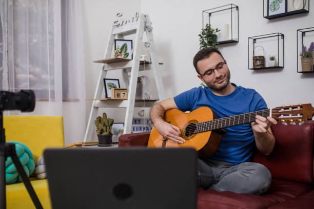 istock Man giving guitar lesson via streaming 1365363235