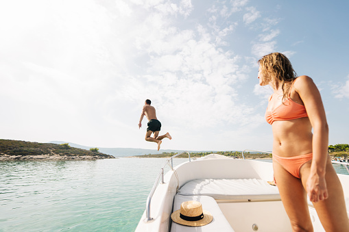 Photo of a couple jumping into the sea from the boat