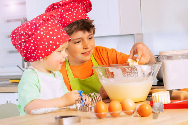 istock Boys add eggs and butter to mixing bowl cooking 1365363429