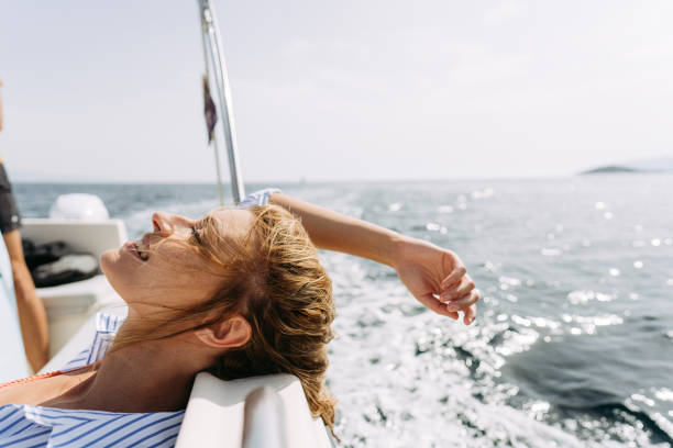 Photo of a smiling woman enjoying a summer day on the boat