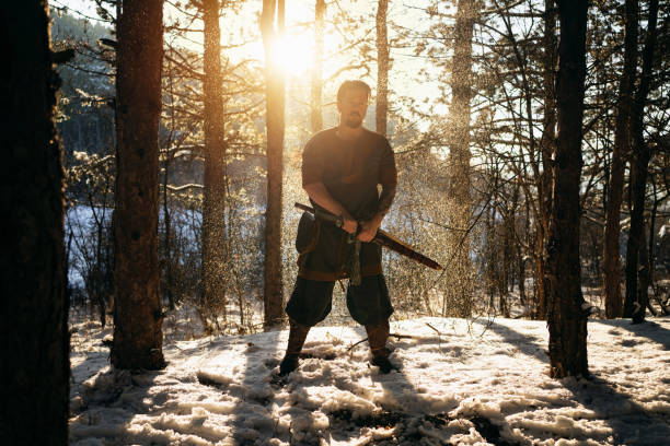 istock Brave medieval warrior in the forest during winter, with swords in his hands 1365365236