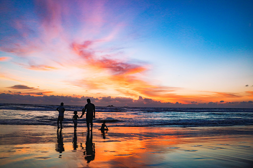 Family with two children walking on Bentota beach, Sri Lanka