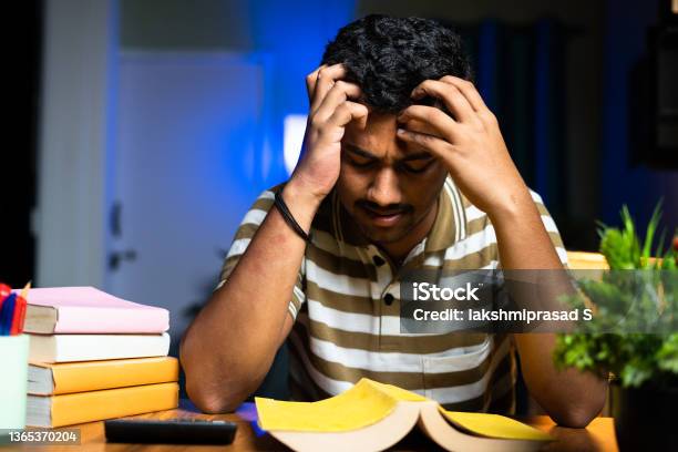 Young Student Reading On Midnight Exam Preparation Reading Not Understanding Books At Home Concept Of Reading Problem Or Difficulties Trouble Seeing At Night Studying Stock Photo - Download Image Now
