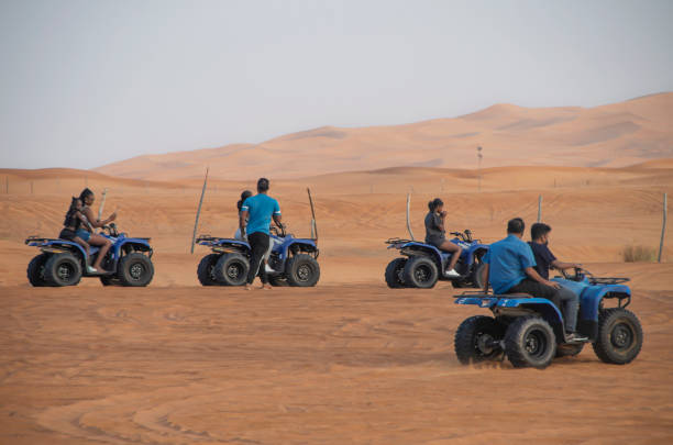2021년 11월 18일 아랍에미리트 두바이 - 아라비아 반도에서 가장 큰 두바이의 루브 알 칼리 사막의 모래 언덕을 가로질러 atv를 타는 사람들. - 4x4 desert sports utility vehicle dubai 뉴스 사진 이미지