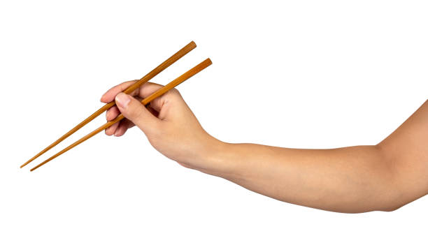 istock Person 's right hand using bamboo chopsticks isolated white background 1365370307