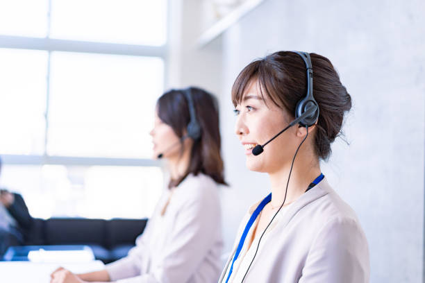 Operator answering the phone with a smile Operator answering the phone with a smile telephone worker stock pictures, royalty-free photos & images