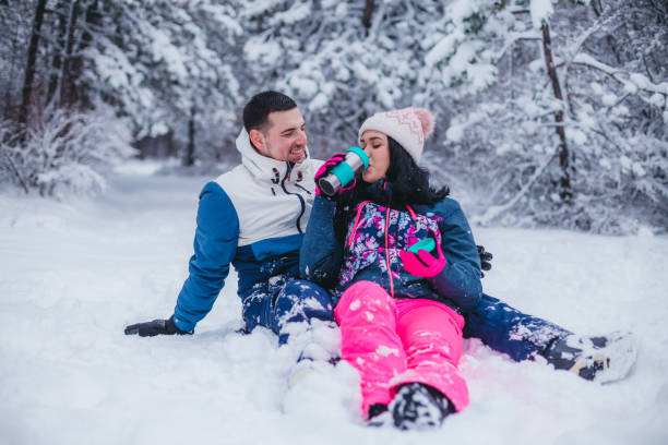 istock A young couple is sitting on the snow drinking tea from a thermos 1365371063