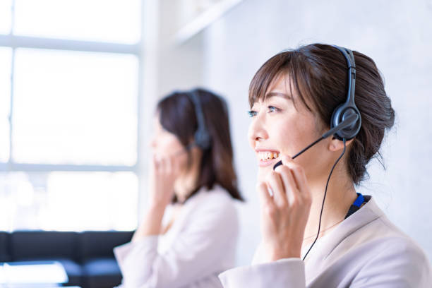 笑顔で電話に出るオペレーター - hotel reception customer service representative headset receptionist ストックフォトと画像