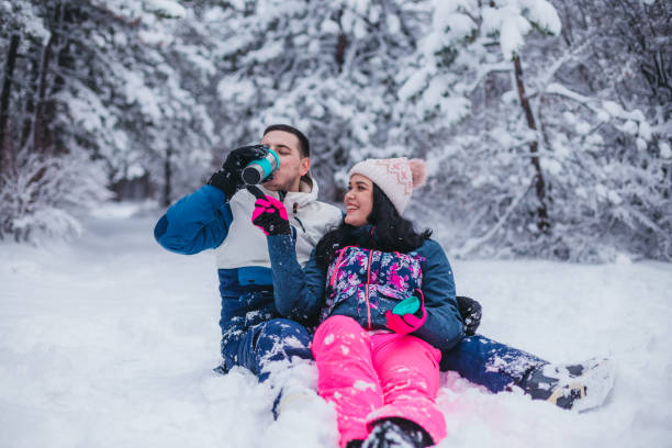 istock A young couple is sitting on the snow drinking tea from a thermos 1365371114