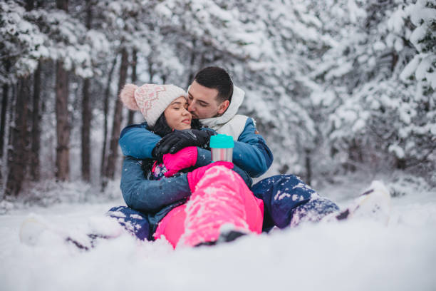 istock A young couple is sitting on the snow drinking tea from a thermos 1365371247