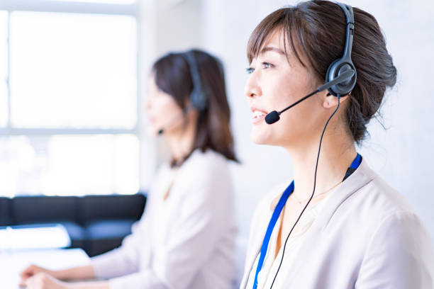 operator answering the phone with a smile - hotel reception customer service representative headset receptionist imagens e fotografias de stock