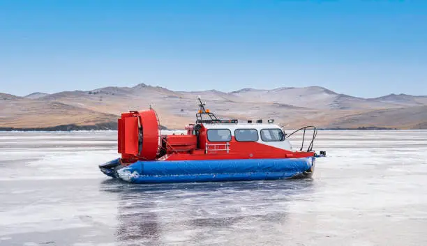 Photo of Hovercraft - Khivus on Lake Baikal. Khivus, airboat, winter transport extreme. Hovercraft sliding fast on the surface of the transparent frozen Lake Baikal, beauty of nature.