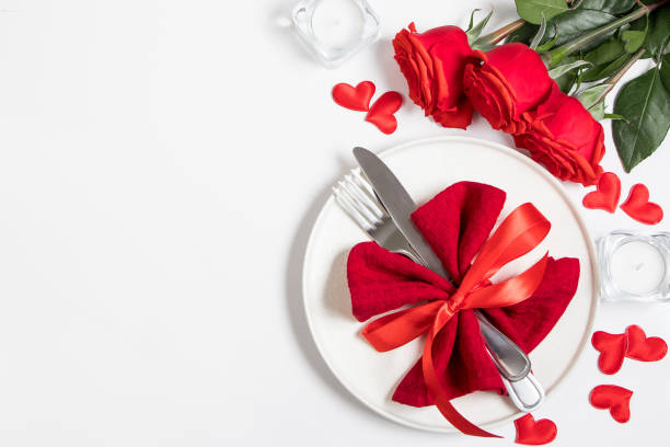 istock Table setting for valentine's day. Red roses and cutlery on a white background. 1365373254