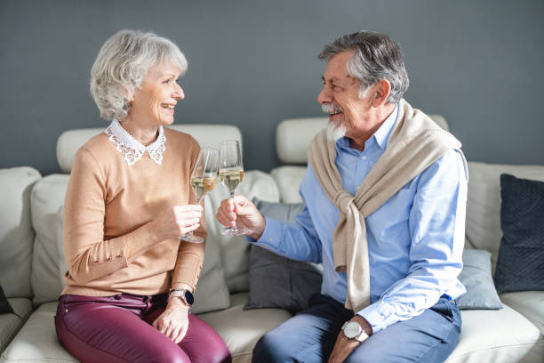 istock Senior couple celebrating with champagne at home 1365373837