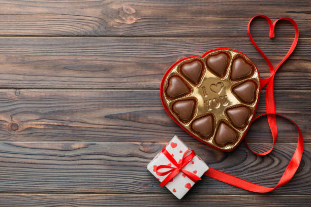 delicious chocolate pralines in box for valentine's day. heart shaped with gift box of chocolates top view with copy space - valentines day candy carnation chocolate candy imagens e fotografias de stock