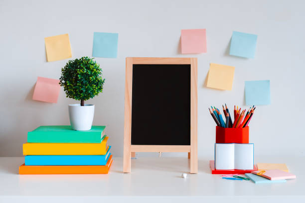 istock Student creative desktop layout with colorful stationery, colored pencils and bright books on a white wall background. 1365375810