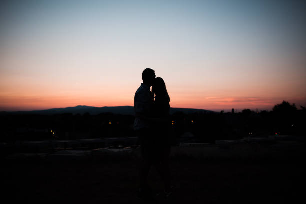 istock Young married couple enjoying the sunset 1365376599