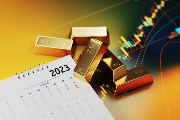 koncepcja inwestycji i finansów - kalendarz 2023 siedzący obok złotych bloków na żółtym tle wykresu finansowego - gold bullion ingot stock market zdjęcia i obrazy z banku zdjęć