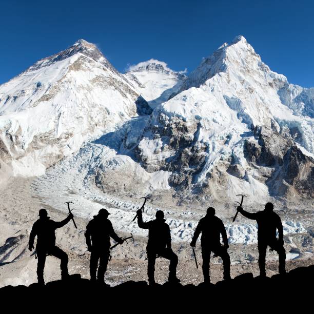 istock Mount Everest with black silhouette of five climbers 1365376716