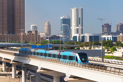 Dubai metro train with city skyline behind, Dubai, United Arab Emirates.