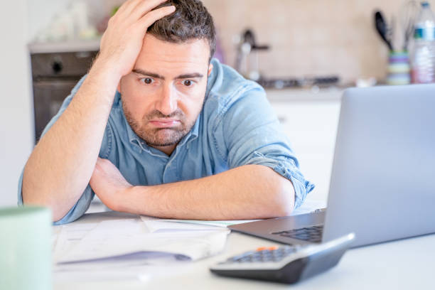 Worried broke man about money problem and home finances One stressed man calculate bills worried about bankruptcy financial problem budget cut stock pictures, royalty-free photos & images