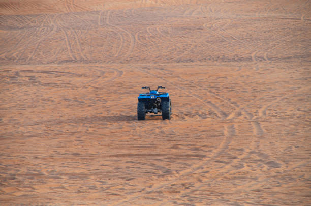 puissant sable de vtt moderne parmi les dunes de sable arabes. quad, le désert de rub al-khali à dubaï - 4x4 desert sports utility vehicle dubai photos et images de collection