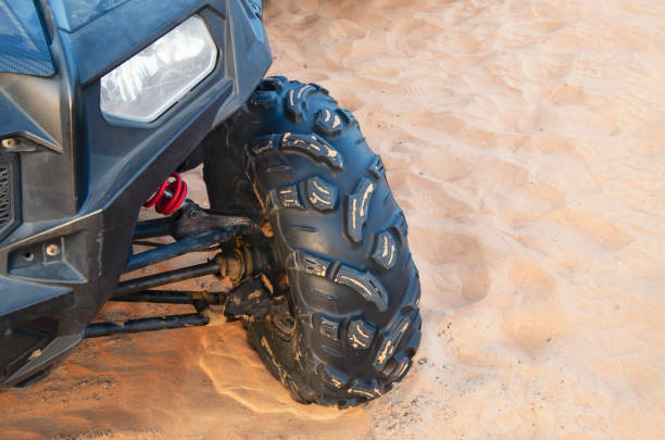 Close-up of a wheel protector of a powerful modern ATV on the sand among the Arabian sand dunes. Quad bike, Rub al Khali desert in Dubai Close-up of a wheel protector of a powerful modern ATV on the sand among the Arabian sand dunes. Quad bike, Rub al Khali desert in Dubai. shipping motorcycles stock pictures, royalty-free photos & images