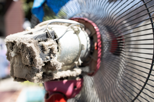Close up,The electric fan motor was covered in dirt,full of dust inside the fan,dusty clogged motor of electric fan,cleaning,maintenance of home appliances,health care,prevent allergy dust,allergies