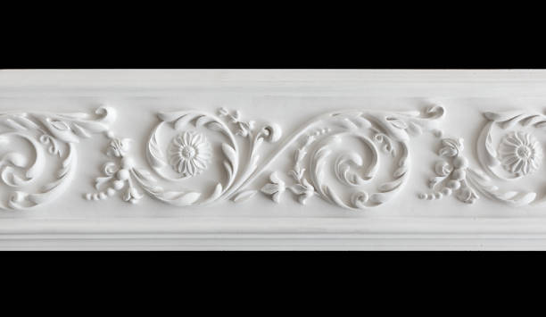 A fragment of a white plaster ceiling molding with an ornament. A fragment of a white plaster ceiling molding with an ornament. Isolated on black, close-up architectural cornice stock pictures, royalty-free photos & images