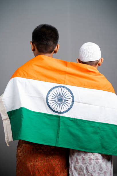 visão traseira da bandeira indiana infantil sobre crianças multi-religiosas ombro em fundo cinza - conceito de liberdade, amizade, unidade na diversidade, nacionalismo e patriotismo. - islam child indian culture ethnic - fotografias e filmes do acervo