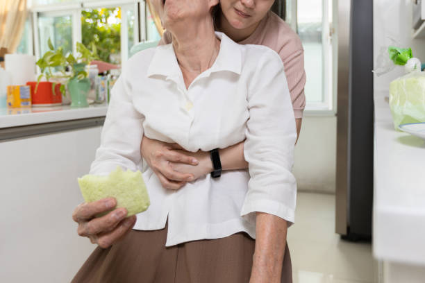 빵이 목에 걸린 아시아 노인 여성, 질식, 응급 처치, 인명 구조 로 인한 기관에서 질식 이나 음식 방해로 고통받는 노인들을 돕는 간병인"n - choking 뉴스 사진 이미지