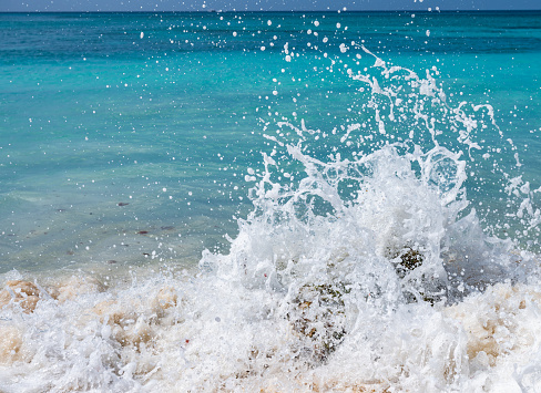 splashing waves crashing on the rocky shore at dawn sun