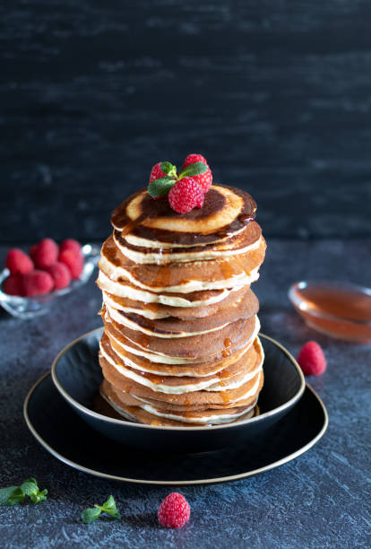 istock Stack of pancakes with raspberrie and maple syrup on black background 1365386019