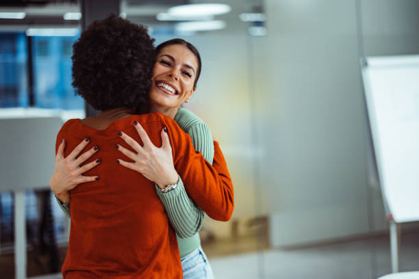 Overjoyed caucasian woman, feeling happy after meeting her new colleague. Joyful adult woman, laughing after greeting her coworker. embracing stock pictures, royalty-free photos & images